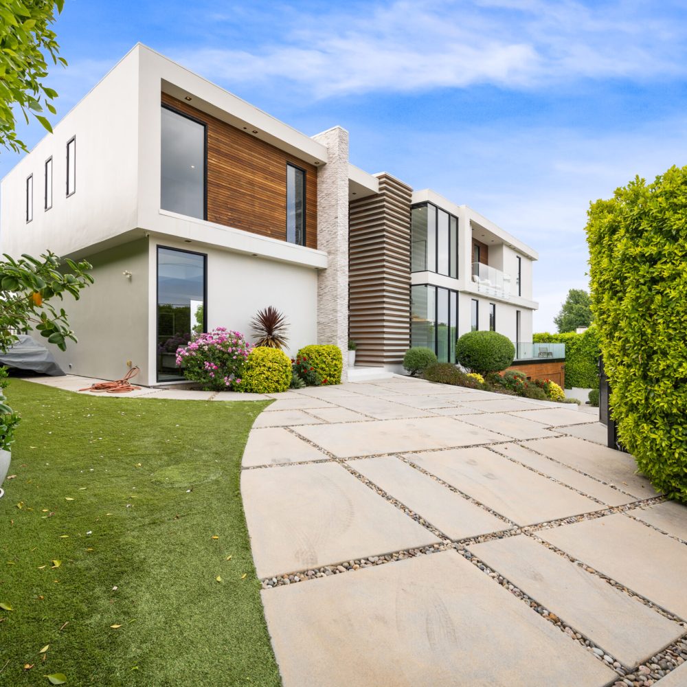 A Driveway of a contemporary house with a garden area